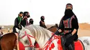 Perempuan Arab berpose saat menunggangi kuda dalam Festival Souk Okaz 2019 di Kota Taif, Arab Saudi, Rabu (7/8/2019). Tahun ini merupakan pertama kalinya perempuan diizinkan untuk berpartisipasi dalam Festival Souq Okaz 2019. (AMER HILABI/AFP)