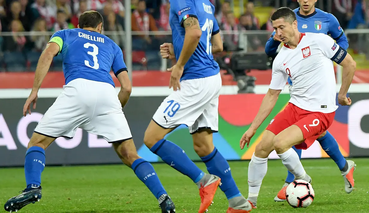 Striker Polandia, Robert Lewandowski berusaha melewati dua pemain Italia, Giorgio Chiellini dan Leonardo Bonucci  pada laga UEFA Nations League Grup 3 di Silesian Stadium, Polandia (14/10). Italia menang 1-0 atas Polandia. (AFP Photo/Janek Skarzynski)