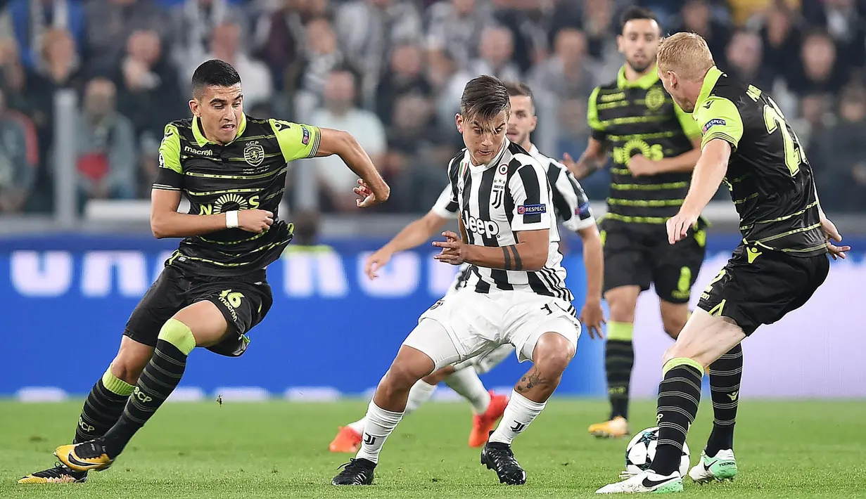 Striker Juventus, Paulo Dybala, berusaha melewati kepungan pemain Sporting Lisbon pada laga Liga Champions di Stadion Allianz, Turin, Rabu (18/10/2017). Juventus menang 2-1 atas Sporting. (AP/Alessandro Di Marco)