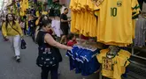 Seorang penggemar sepak bola Brasil melihat-lihat jersey tim nasional sepak bola yang dipajang di pasar Saara, Rio de Janeiro, Brasil, pada Selasa 9 Juni 2026, menjelang turnamen Piala Dunia FIFA 2026. (Nelson ALMEIDA/AFP)