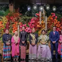 Menteri Pariwisata Widiyanti Putri hadir di resepsi pernikahan bersama suaminya. Ibu menteri ini memilih mengenakan kebaya hitam panjang dipadukan bawahan kain merah. [@widi.wardhana]