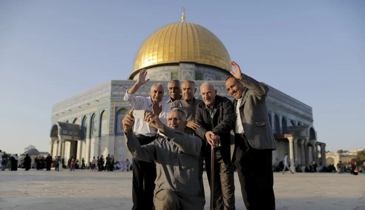 Hussam Abu Daba'a (tengah) berfoto selfie dengan teman-temannya di depan kubah Ash-Shakhrah di area Masjid Al-Aqsa, Yerusalem, 29 Juni 2015. (REUTERS/Ammar Awad) 