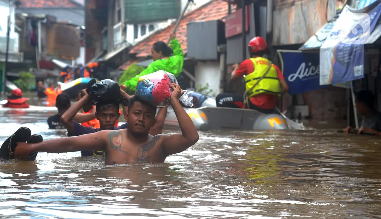 Warga menyusuri banjir yang merendam kawasan Karet Pasar Baru Barat, Jakarta, Selasa (25/2/2020). Banjir yang terjadi sejak subuh akibat luapan Kanal Banjir Barat tersebut merendam ratusan rumah hingga setinggi dua meter. (merdeka.com/Arie Basuki)