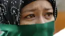 Salah satu wanita muslim Filipina tak kuasa menahan tangis saat melakukan unjuk rasa menentang agresi militer Israel ke jalur Gaza, (15/7/2014). (REUTERS/Erik De Castro)