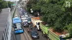 Kendaraan terjebak kemacetan di Jalan Sultan Agung, Jakarta, Selasa (8/8). Banyaknya truk proyek pembangunan Pasar Rumput menyebabkan kemacetan parah di kawasan tersebut karena parkir hingga menutup sebagian jalur. (Liputan6.com/Immanuel Antonius)