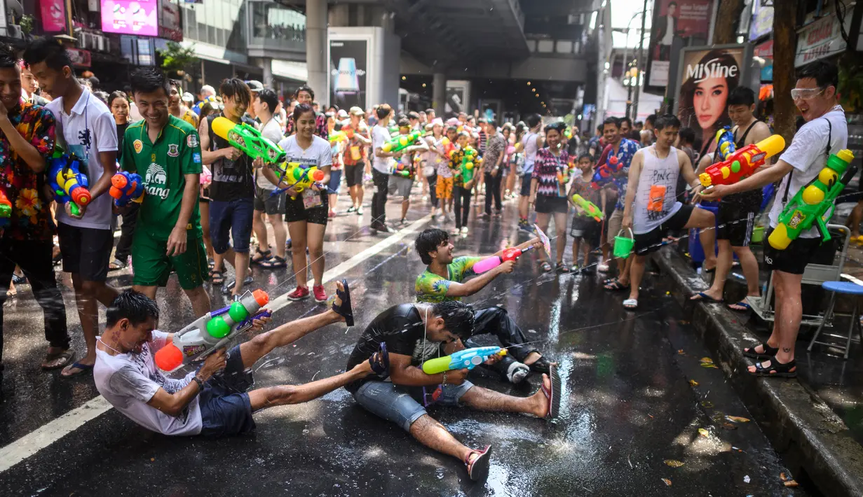 Warga bersuka ria saat perang air dalam Festival Songkran atau Tahun Baru Thailand di Bangkok, 14 April 2019. Perang air menimbulkan kemacetan di jalanan seantero kota. (Permata SAMAD/AFP)