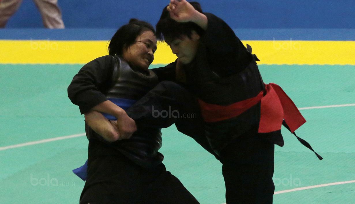 Aksi pesilat Laos, Olahthai Sounthavong beursaha membanting Octaviani Nirmalasari (kanan) pada semifinal Test Event Pencak Silat 2018 di Padepokan Silat TMII, Jakarta, (12/2/2018). Oktaviani menang 5-0. (Bola.com/Nick Hanoatubun)