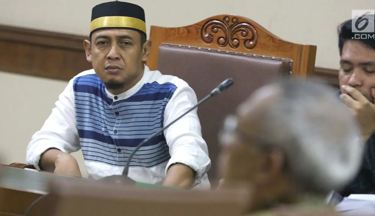 Terdakwa penyebaran berita bohong tentang 7 kontainer berisi surat suara Pemilu 2019 yang telah tercoblos, Bagus Bawana Putra menyimak keterangan Kepala Biro Hukum Sekjen KPU, Sigit Joyowardono saat sidang lanjutan di Pengadilan Negeri Jakarta Pusat, Kamis (11/4). (Liputan6.com/Helmi Fithriansyah)