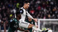 Striker Juventus, Cristiano Ronaldo, berebut bola dengan bek Bologna, Ibrahima Mbaye, pada laga Serie A Italia di Stadion Juventus, Turin, Sabtu (19/10). Juventus menang 2-1 atas Bologna. (AFP/Marco Bertorello)