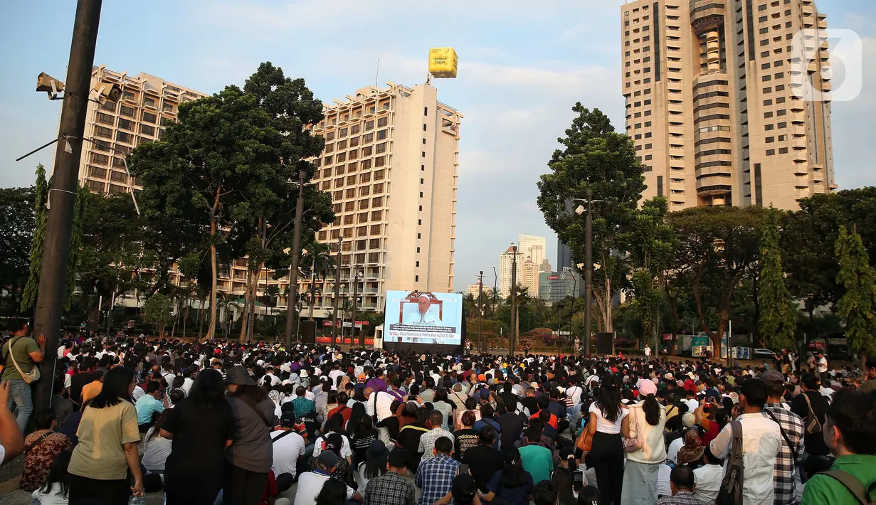 Umat katolik saat mengikuti misa agung melalui layar lebar di area Parkir Timur Gelora Bung Karno (GBK) Senayan, Jakarta, Kamis (5/9/2024). (Liputan6.com/Angga Yuniar)