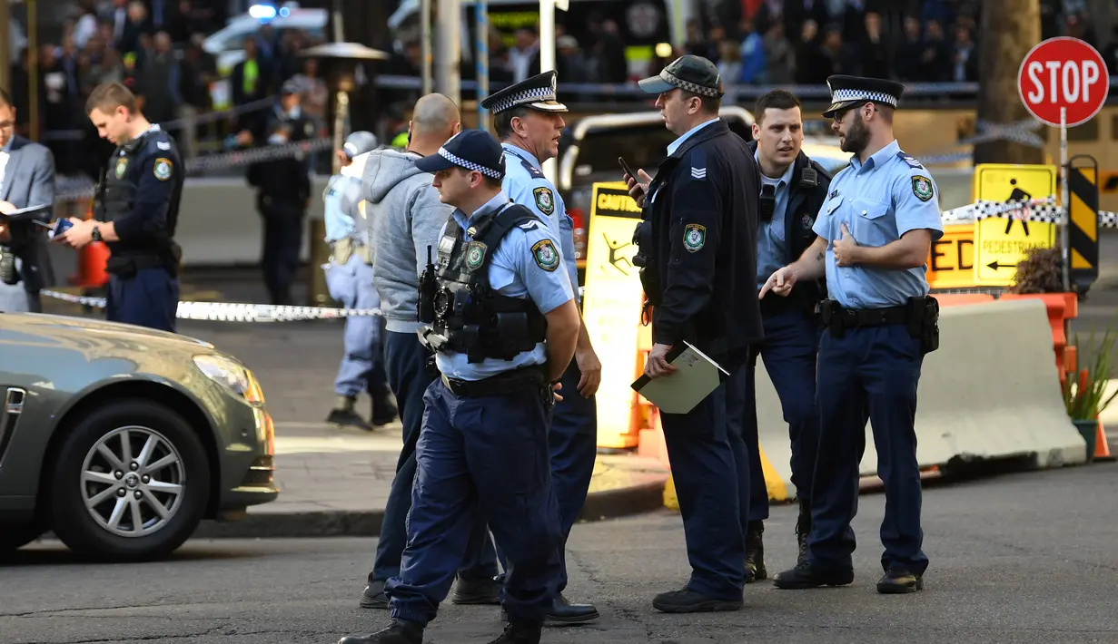 Polisi berjaga di tempat kejadian setelah seorang pria menikam seorang wanita dan berusaha menikam orang lain di pusat kota Sydney (13/8/2019). Polisi mengatakan wanita itu dalam kondisi stabil tidak mengalami luka. (AFP Photo/Saeed Khan)
