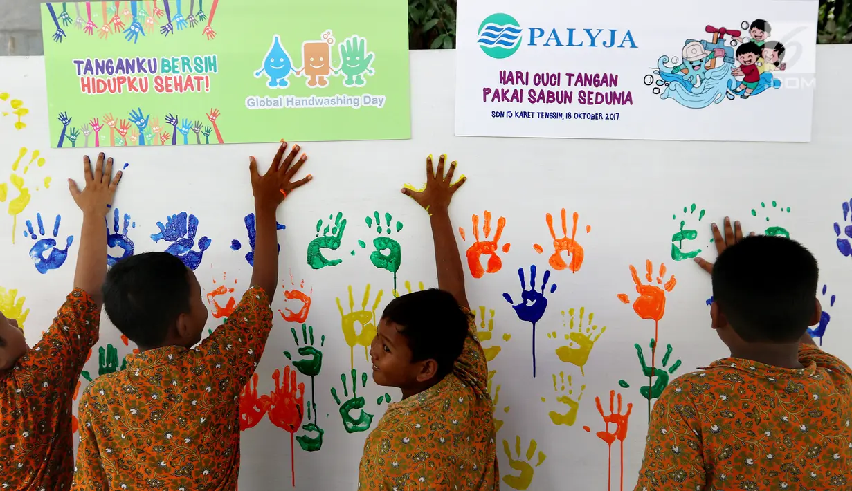 Siswa menempel tangan berlumuran cat air ke dinding di SD Negeri 15 Karet Tengsin, Jakarta, Rabu (18/10). Kegiatan ini digelar dalam rangka Hari Cuci Tangan Pakai Sabun Sedunia yang jatuh setiap tanggal 15 Oktober. (Liputan6.com/Fery Pradolo)