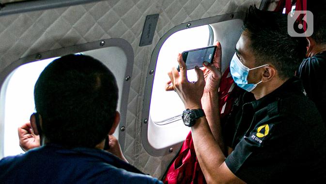 Awak media memantau proses pencarian pesawat Sriwijaya Air SJ 182 dari pesawat CN 295 milik TNI AU di perairan Kepulauan Seribu, Jakarta, Minggu (10/1/2021). TNI AU menargetkan proses pencarian Sriwijaya Air SJ 182 maksimal selama tujuh hari. (Liputan6.com/Faizal Fanani)