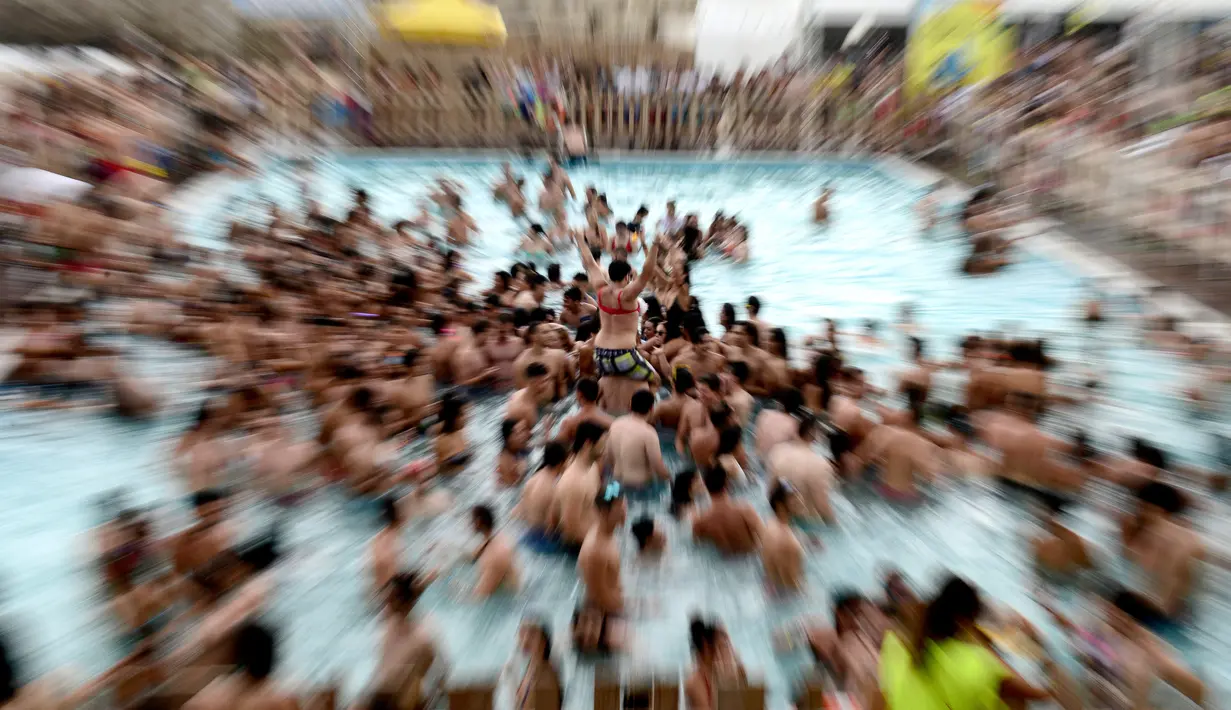 Suasana di kolam selama Festival Arenal Sound di Pantai Burriana, Spanyol (2/8). Festival musik enam hari ini menampung sekitar 240.000 orang. (AFP Photo/Jose Jordan)