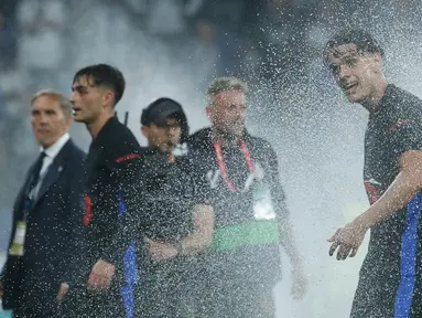 Pemain Barcelona, Hector Fort, menikmati siraman air dari lapangan usai mengunci gelar juara LaLiga 2024/2025 setelah mengalahkan Espanyol pada pertandingan ke-36 di RCDE Stadium, Jumat dini hari WIB (16/5/2025). (AP Photo/Joan Monfort)
