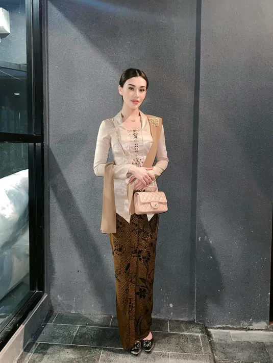 Terbaru di acara tedak siten Azura, Aaliyah tampil elegan dengan kebaya velvet berwarna coklat muda, lengkap dengan selendang dan kain batiknya.  [@aaliyah.massaid/@sarahmenzel].