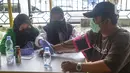 Petugas medis mengecek kesehatan warga sebelum mengikuti program vaksinasi massal Covid-19 di PMI Kota Bekasi, Jawa Barat, Sabtu (21/08/2021). Vaksin yang digunakan dalam vaksinasi massal tersebut yakni vaksin Astrazeneca. (Liputan6.com/Herman Zakharia)