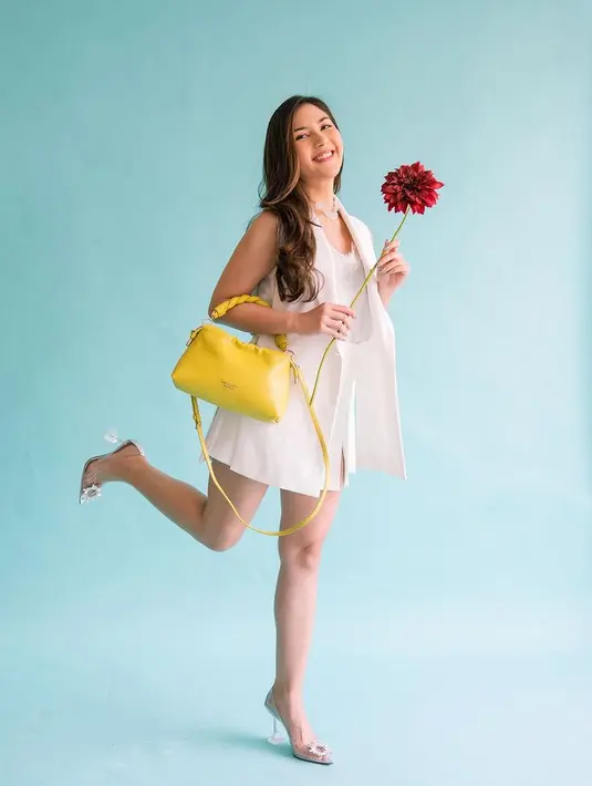 <p>Tampil serba putih juga semakin memesona dengan paduan tas bernuansa kuning, memberikan kesan pop yang unik dan menggemaskan. (Foto: Jessica Mila)</p>