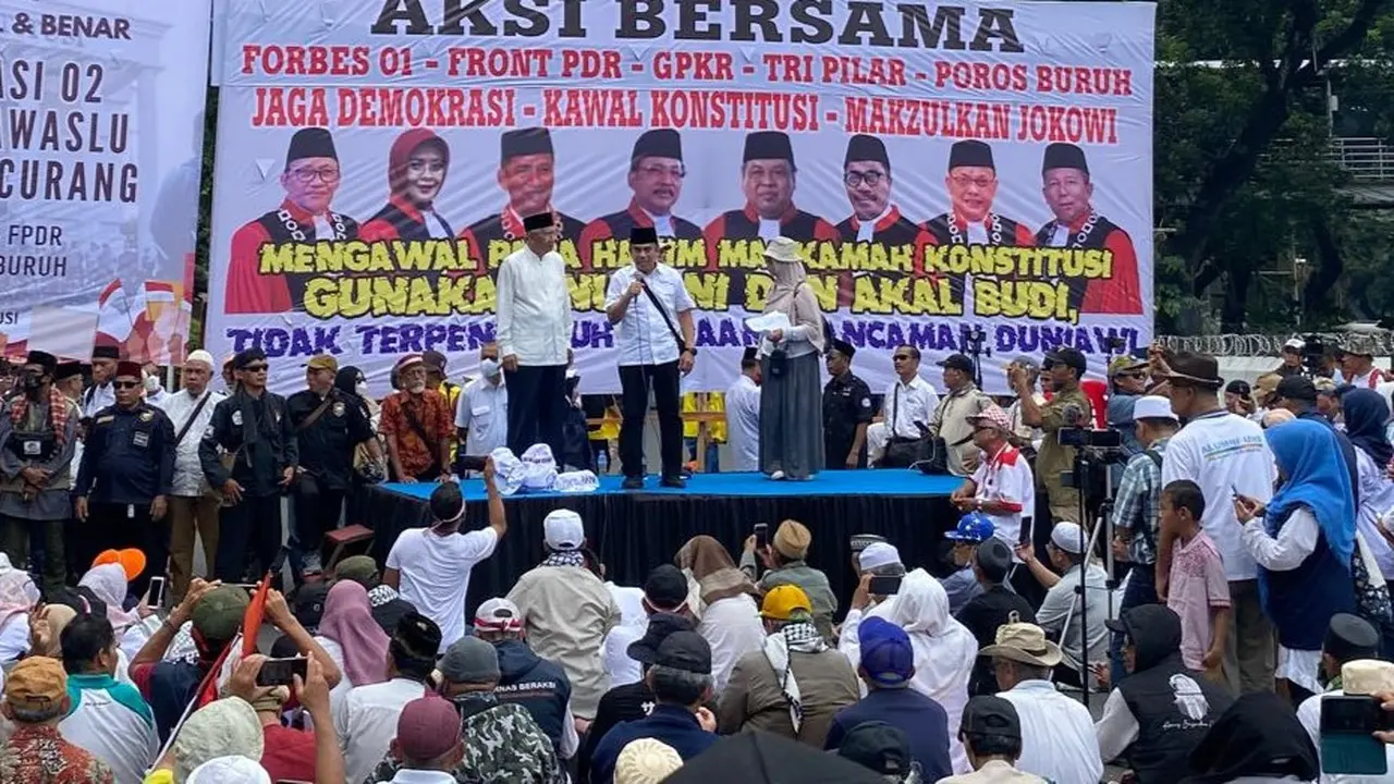 Sekelompok massa menggelar aksi di kawasan Patung Kuda, Jalan Medan Merdeka Barat, Jakarta Pusat, Jumat (19/4/2024).