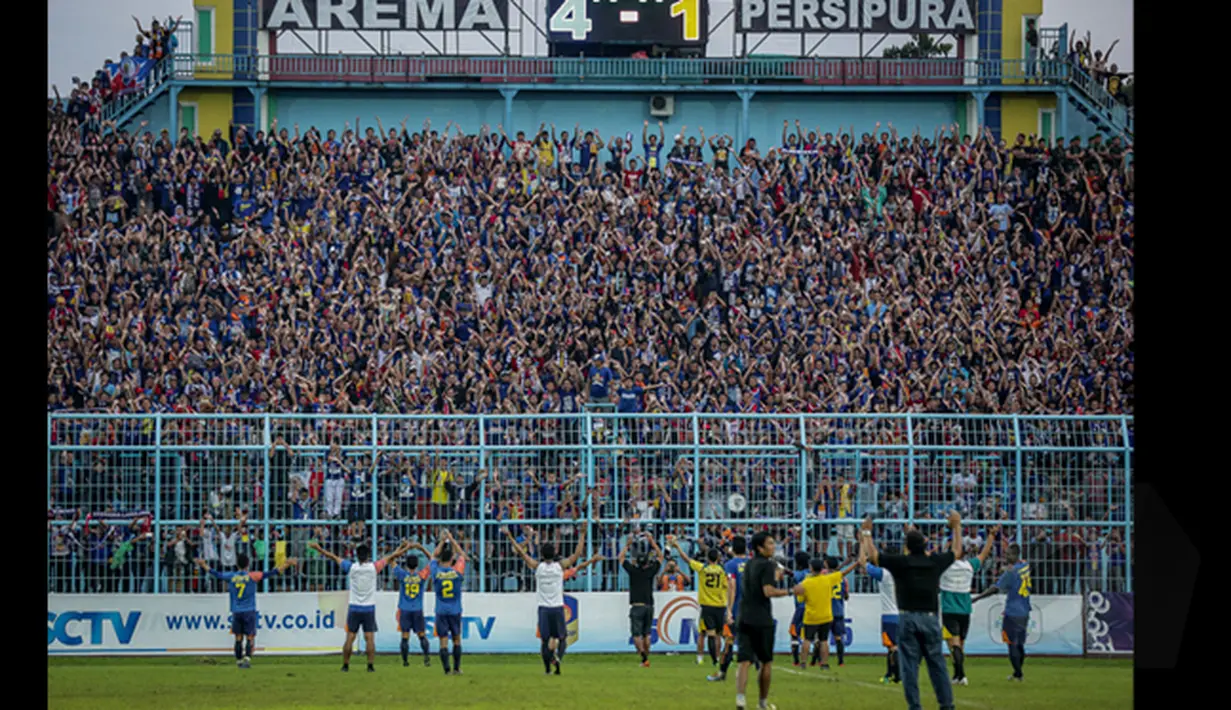 Suporter Arema Cronus memberikan dukungan kepada tim kesayangan mereka saat laga di SCM Cup 2015 di SCM Cup 2015 di Stadion Kanjuruhan, Malang, Kamis (22/1/2015)). Arema Cronus menang 4-1 atas Persipura (Liputan6.com/Faizal Fanani)