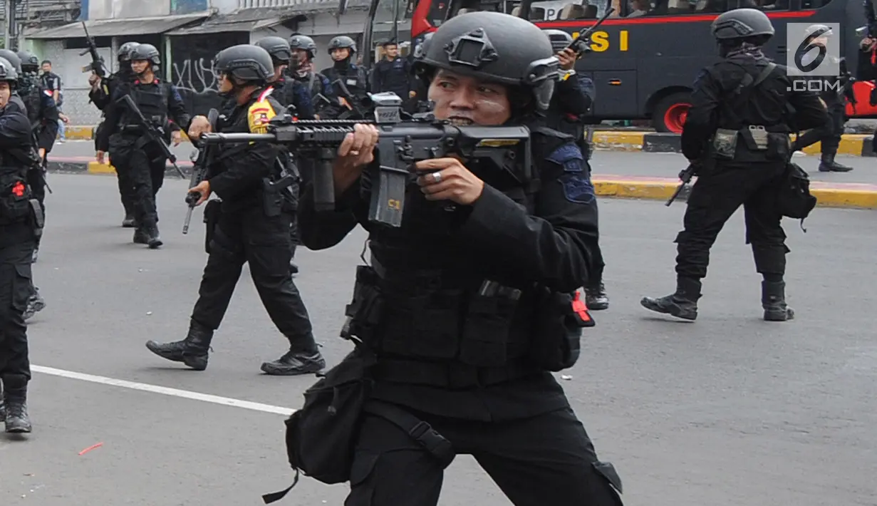 Personel Brimob mengusir massa usai terjadi pembakaran bus milik Brimob Polda Metro Jaya di kawasan Jalan Brigjend Katamso, Slipi, Jakarta, Rabu (22/5/2019). Selain dua bus milik Brimob, tiga bus dan satu mobil lainnya juga rusak berat akibat dilempari batu oleh massa. (merdeka.com/Arie Basuki)