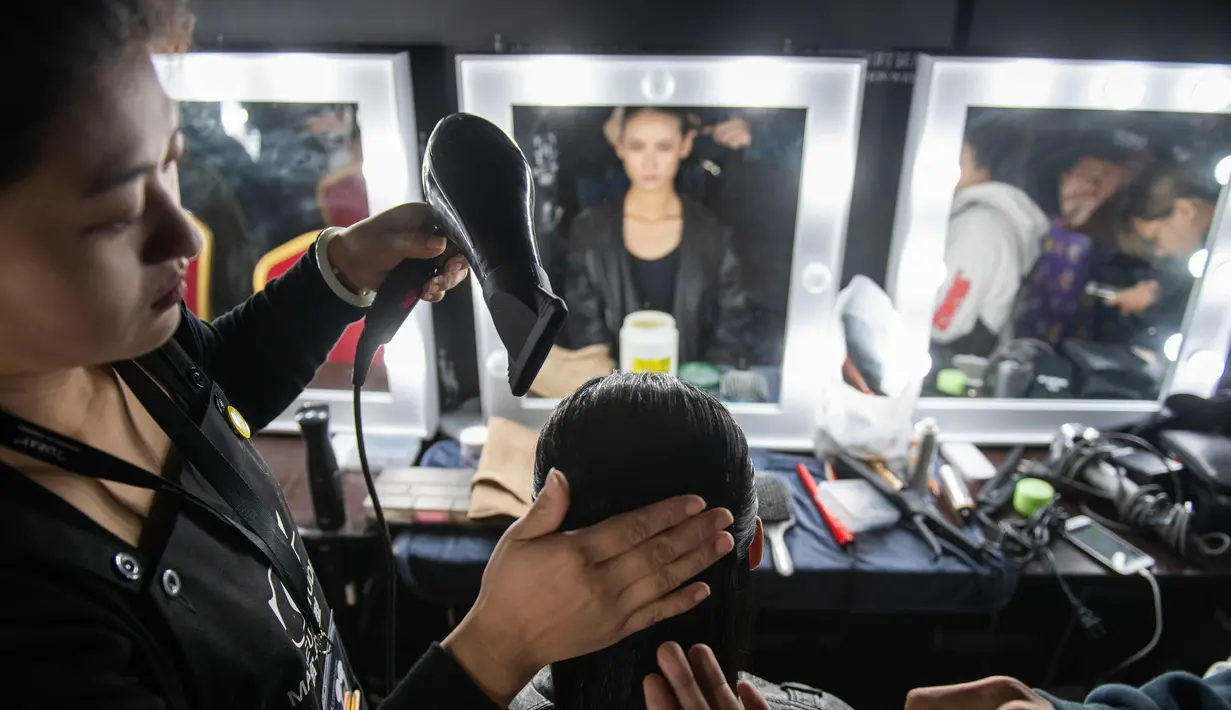 Model saat dirapihkan rambutnya di belakang panggung sebelum tampil membawakan koleksi Rabbit-Warm karya Zhuang Ganran selama China Fashion Week di Beijing (30/10). (AFP Photo/Nicolas Asfouri)