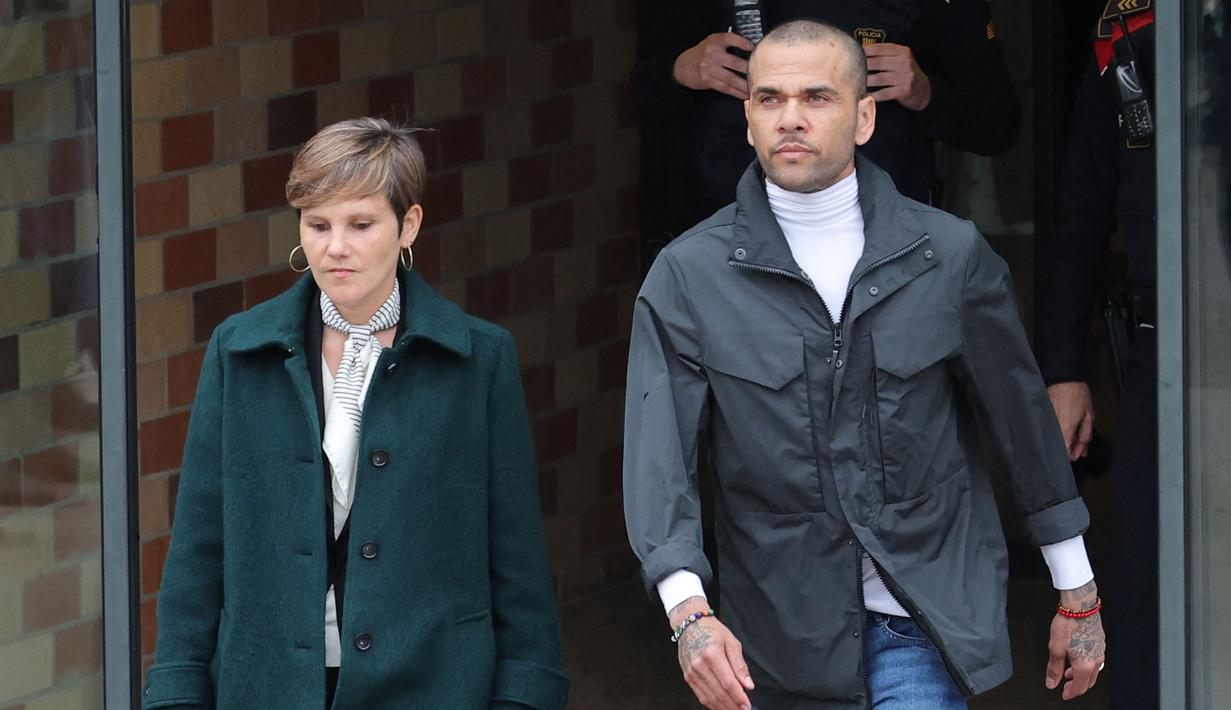 Pemain Brasil, Dani Alves (kanan) bersama pengacaranya, Ines Guardiola berjalan meninggalkan penjara Brians 2 di San Esteban Sasroviras, Barcelona, Spanyol, 25 Maret 2024. Alves bebas dari penjara setelah membayar uang jaminan 1 juta euro ke Pengadilan Barcelona. (AFP/Lluis Gene)