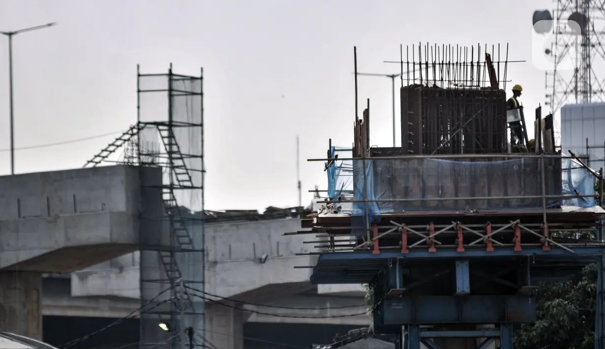Aktivitas pekerja saat menyelesaikan proyek pembangunan Tol Becakayu seksi 1A di kawasan Pasar Gembrong, Jakarta, Selasa (14/7/2020). Proyek pembangunan Tol Becakayu seksi 1A rute Kampung Melayu-Cipinang Muara sepanjang 3,5 kilometer tersebut molor dari target. (merdeka.com/Iqbal S. Nugroho)