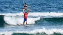 Atlet Prancis, Rico Leroy dan Sarah Burel, beraksi dalam Kejuaraan Internasional Surfing Tandem di Biscarrosse, Prancis, (23/7/2016). (AFP/Mehdi Fedouach)