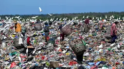Untuk diketahui, sejak 1 April 2026, TPA Suwung hanya menerima sampah residu dan anorganik, sementara sampah organik dilarang masuk. Tampak dalam foto, orang-orang mengumpulkan sampah di Tempat Pembuangan Akhir (TPA) Suwung, Denpasar, Bali, pada Jumat 17 April 2026. (SONNY TUMBELAKA/AFP)
