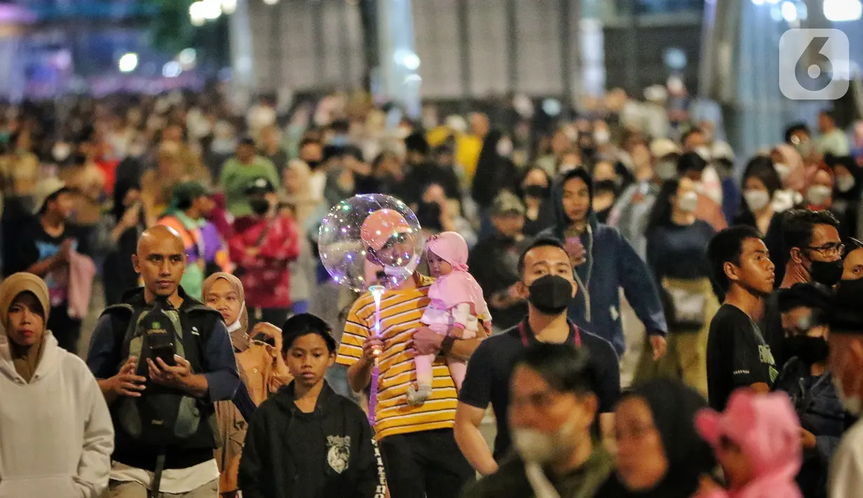 Warga memadati Car Free Night (CFN) pada malam pergantian tahun baru 2023 di kawasan Bundaran Hotel Indonesia, Jakarta, Sabtu (31/12/2022). Banyak warga yang berkumpul merayakan pergantian tahun baru sambil berswafoto, menikmati kuliner, berjalan hingga bersepeda santai. (Liputan6.com/Angga Yuniar)