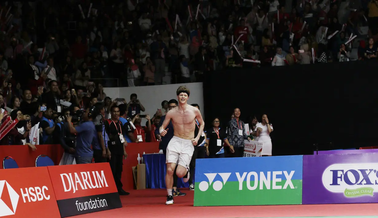 Pebulutangkis Denmark, Anders Antonsen, melakukan selebrasi buka baju usai mengalahkan wakil Jepang, Kento Momota, pada laga Indonesia Masters 2019 di Istora, Jakarta, Minggu (27/1). Antonsen menang 21-16, 14-21, 21-16. (Bola.com/M Iqbal Ichsan)