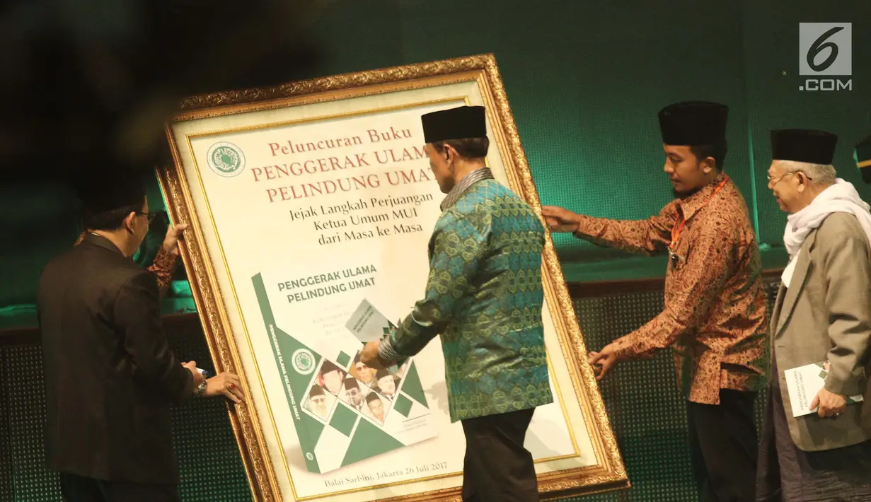 Menkopolhukam Wiranto menandatangani poster buku Penggerak Ulama Pelindung Umat pada acara Milad MUI ke-42 dan Anugerah Syiar Ramadhan 2017 di Jakarta, Kamis malam (26/7). (Liputan6.com/Herman Zakharia)