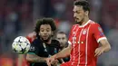Pemain Real Madrid, Marcelo berebut bola dengan pemain Bayern Munchen, Mats Hummels pada leg pertama semifinal Liga Champions di Allianz Arena, Rabu (25/4). Real Madrid meraih kemenangan 2-1 saat bertandang ke markas Bayern Munchen. (AP/Matthias Schrader)
