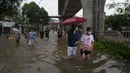 Warga berjalan menyusuri banjir yang merendam Jalan Kapten Tendean, Jakarta, Sabtu (20/2/2021). Banjir yang disebabkan curah hujan tinggi memutus akses lalu lintas di Jalan Kapten Tendean. (merdeka.com/Imam Buhori)