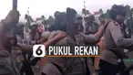 Salah seorang polisi memukul kepala rekannya dengan tonfa.