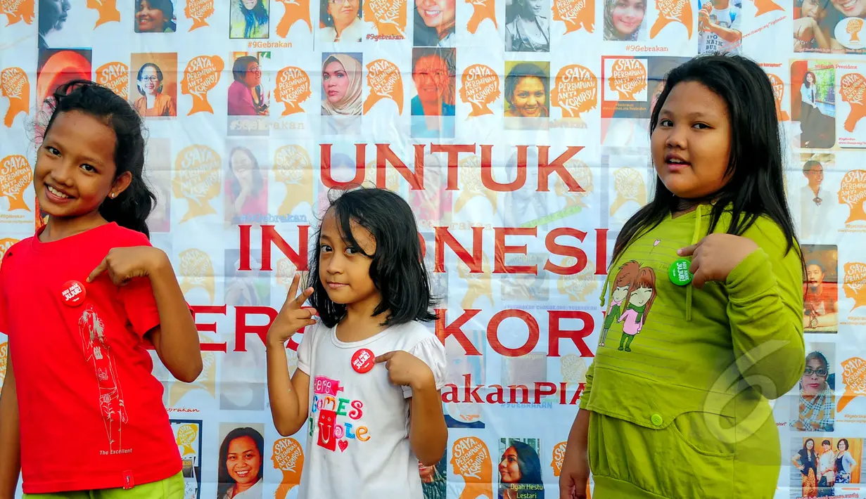 Anak kecil berpose sambil menunjukan pin bertuliskan 'Saya Anak Jujur' yang diberikan usai membubuhkan cap tangan sebagai bentuk dukungan kepada Perempuan Anti Korupsi di Bundaran HI, Jakarta, Minggu (8/3/2015). (Liputan6.com/Yoppy Renato)