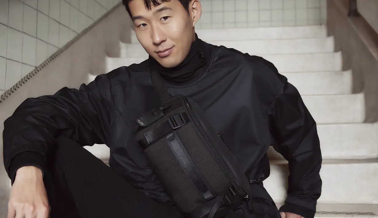 Mengenakan crossbody bag, Son Heung Min menyelaraskan outfitnya dengan bomber jacket dan trainy pants berwarna hitam. Crossbody bag yang dikenakannya merupakan Platoon Sling yang menjadi tas bebas genggaman yang kasual dan bergaya.