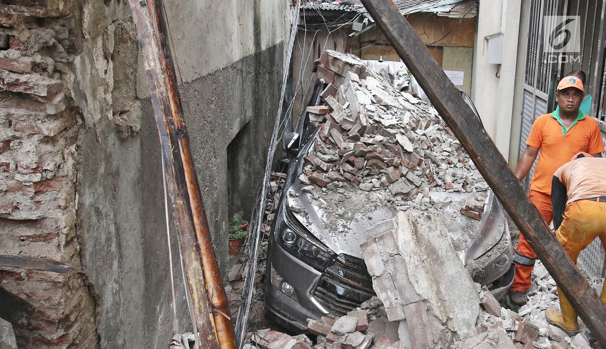 Sebuah mobil tertimpa bangunan SMPN 32 Pekojan Jakarta Barat yang roboh pada Kamis (21/12). Bangunan di Jalan Perniagaan, Kecamatan Tambora, Jakarta Barat ini dibuat tahun 1880. (Liputan6.com/Herman Zakharia)
