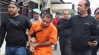 Pelaku pembunuhan seorang perempuan di Kabupaten Indragiri Hulu digiring oleh petugas. (Liputan6.com/M Syukur)
