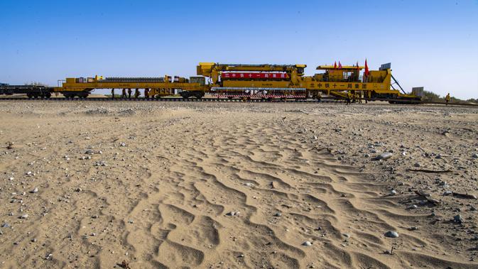 Sebuah mesin menempatkan rel di lokasi konstruksi jaringan kereta Hotan-Ruoqiang di Daerah Otonom Uighur Xinjiang, China, 25 September 2020. Dengan total panjang sekitar 825 kilometer, jaringan kereta itu merupakan bagian penting dari loop kereta di Lembah Tarim. (Xinhua/Hu Huhu)