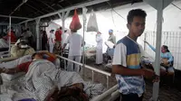 Pasien dievakuasi keluar rumah sakit di Bali menyusul gempa Lombok, Senin (6/8). Gempa 7 pada skala richter yang berpusat di Lombok, menyebabkan kerusakan bangunan di berbagai lokasi di Bali dan mengakibatkan sejumlah warga terluka. (AP/Firdia Lisnawati)