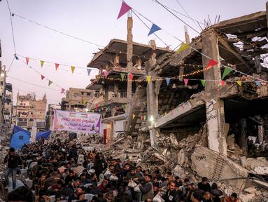 Orang-orang berkumpul untuk berbuka puasa pada hari pertama bulan puasa Ramadan di Jabalia, Jalur Gaza utara, pada 1 Maret 2025. (Bashar TALEB/AFP)