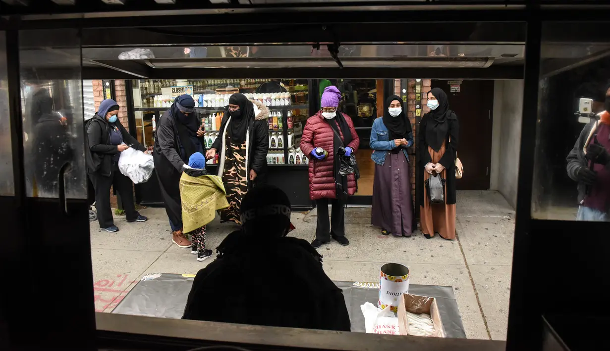 Orang-orang menunggu dalam antrean mengambil makan Halal gratis untuk Iftar selama bulan suci Ramadan di depan Masjid di masjid Taqwa di lingkungan Bedford-Stuyvesant di wilayah Brooklyn di New York (14/5/2020). (Stephanie Keith/Getty Images/AFP)