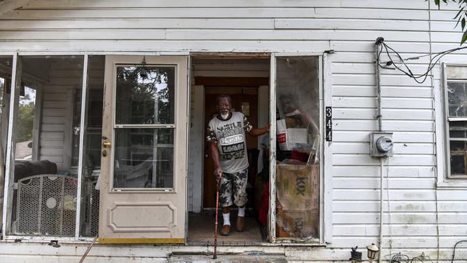 Samuel Hawkins (80) melihat saat dia berjalan keluar dari rumahnya di Fayette, Jefferson County, Mississippi (28/9/2020). Dampak perbudakan di wilayah Amerika Serikat bagian Selatan ini tetap terlihat. (AFP/Chandan Khanna)
