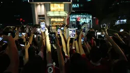  Suporter Manchester United mengambil foto pemain MU saat memasuki bus yang akan membawa ke bandar udara setelah pertandingan melawan Manchester City dibatalkan di Beijing, China. (25/7/2016). (AFP)