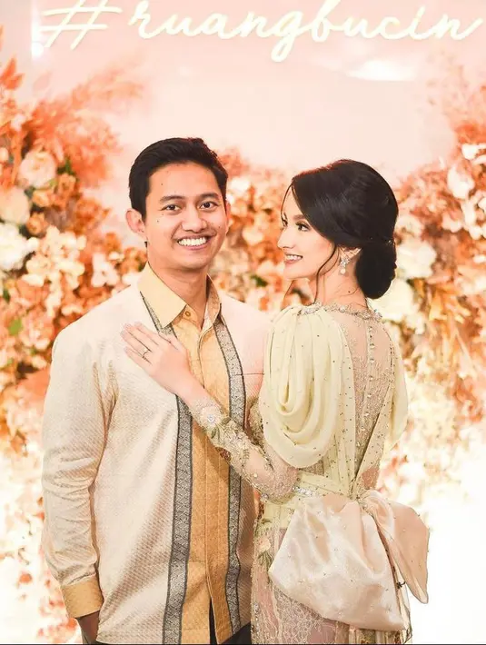 Sementara untuk rambut, Sabrina memilih sleek hair-do dengan sanggul model low bun yang dipermanis dengan hiasan bunga warna pink di atas sanggulnya. (Instagram/belvadevara).