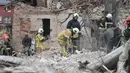 Tim penyelamat mencari korban di reruntuhan rumah yang hancur akibat serangan roket Rusia di pinggiran Lviv, Ukraina, Minggu 5 Oktober 2025. (AP Photo/Mykola Tys)