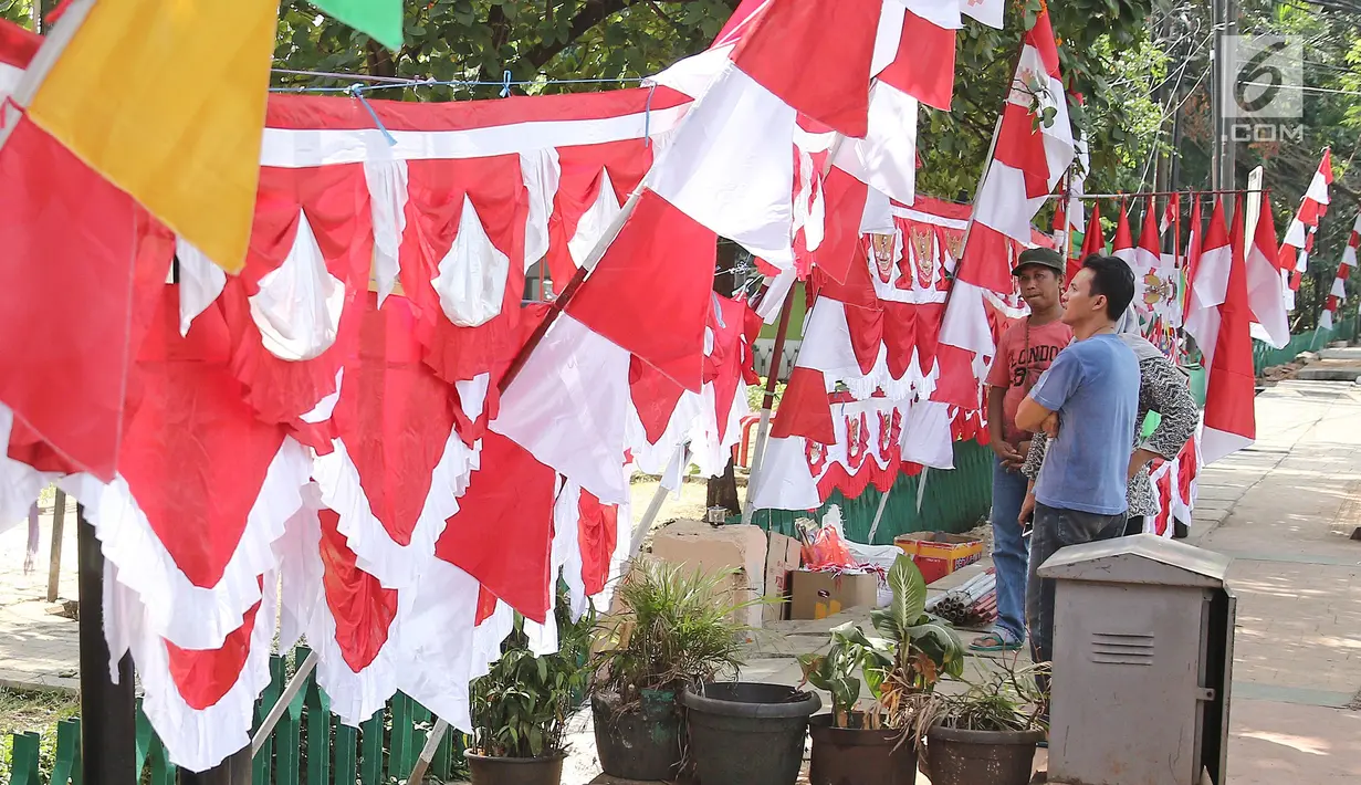 Pembeli melihat bendera dan umbul-umbul yang dijajakan pedagang di pinggir trotoar kawasan Pasar Minggu, Jakarta, Kamis (2/8). Beberapa penjual bendera menawarkan dagangannya seharga Rp15.000-Rp400.000 tergantung ukuran.  (Liputan6.com/Herman Zakharia)