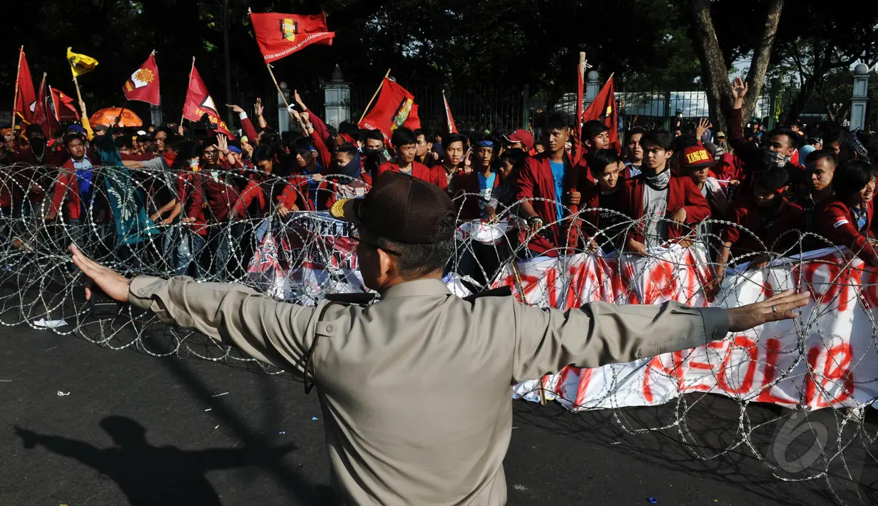 Seorang petugas tampak meminta kepada para mahasiswa untuk tidak melewati kawat berduri, Jakarta, (20/5/2015). Penjagaan ini sebagai antisipasi terjadinya kerusuhan aksi mahasiswa saat memperingati Harkitnas. (Liputan6.com/JohanTallo)